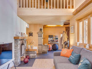 Step into this stunning chalet-style home, boasting a cozy living area with a stone fireplace and a modern TV.