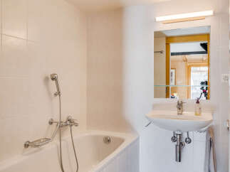 This charming bathroom features a bright and airy design, perfect for relaxation.