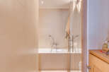 Step into a serene bathroom oasis, featuring a sleek glass shower enclosure and a luxurious bathtub.