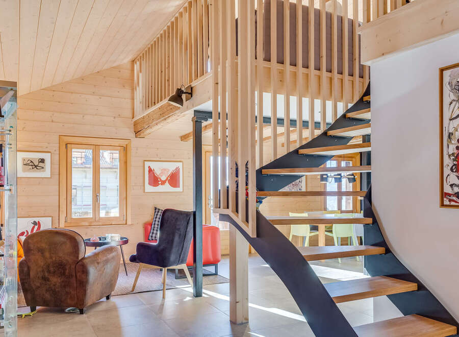 This stunning property boasts a unique architectural design with a modern staircase and a cozy living area.