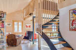 This stunning property boasts a unique architectural design with a modern staircase and a cozy living area.