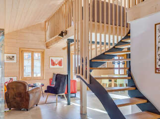 This stunning property boasts a unique architectural design with a modern staircase and a cozy living area.