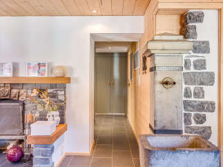 Discover the charm of this unique property, featuring a stunning stone fireplace and a rustic wooden ceiling.