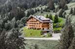 Nestled in a serene mountain landscape, this stunning property boasts a luxurious wooden facade and multiple balconies, offering breathtaking views.