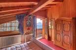 Experience the charm of this cozy bedroom with its warm wooden accents and stunning mountain views.