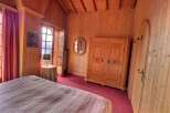 This charming bedroom features warm wooden paneling and a cozy atmosphere.