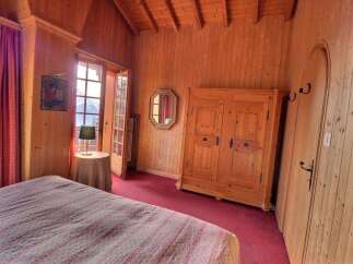 This charming bedroom features warm wooden paneling and a cozy atmosphere.