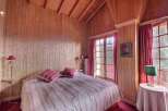 Step into a cozy bedroom retreat with charming wooden paneling and a warm, inviting ambiance.