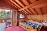 This charming bedroom features a cozy wooden interior with exposed beams and a warm, inviting atmosphere.