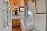 This charming bathroom features a cozy wooden ceiling and a bright, inviting atmosphere.