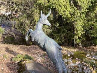 Discover the charm of this unique property, featuring a captivating sculpture of a leaping deer.