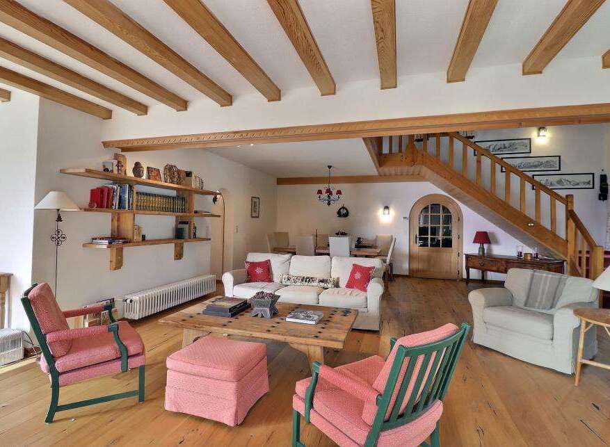 Step into this charming living space, featuring a rustic wooden ceiling and a cozy ambiance.