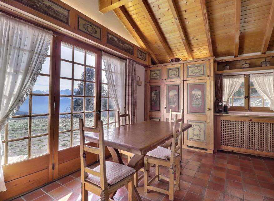 This charming dining room boasts stunning mountain views through large windows, creating a bright and inviting atmosphere.