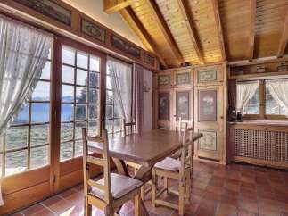 This charming dining room boasts stunning mountain views through large windows, creating a bright and inviting atmosphere.