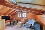 This cozy attic space features a warm, inviting atmosphere with its wooden paneling and exposed beams.