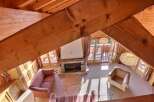 Experience the charm of this cozy chalet, featuring a stunning stone fireplace and exposed wooden beams that create a warm and inviting atmosphere.
