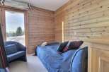 Cozy bedroom featuring wood-paneled walls and a comfortable bed.