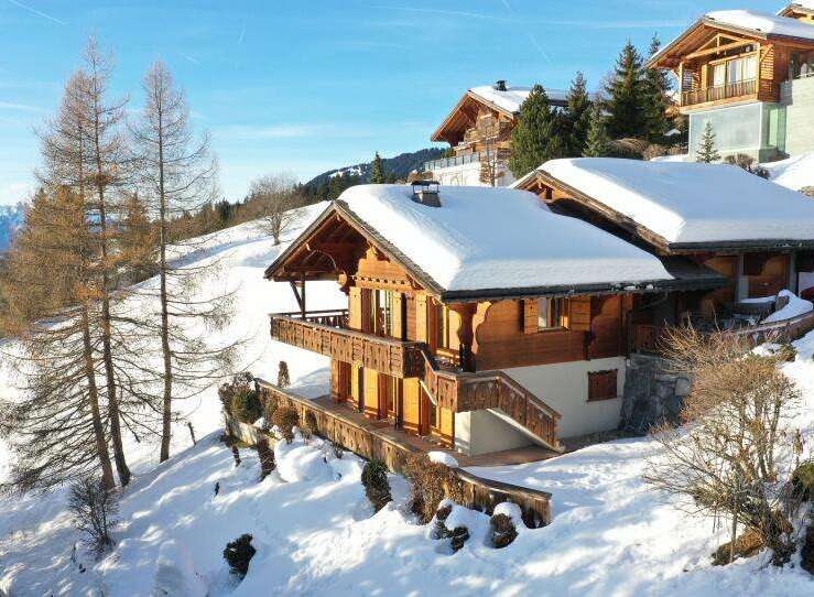 Discover a stunning chalet nestled in a picturesque snowy landscape.