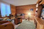 Discover the charm of this cozy home office, featuring warm wood paneling and a stylish desk.