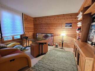Discover the charm of this cozy home office, featuring warm wood paneling and a stylish desk.