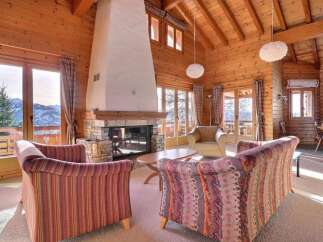 Experience the warmth of this stunning chalet, featuring a cozy fireplace and inviting seating areas.