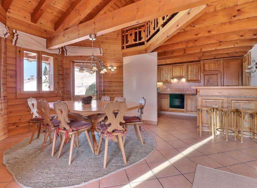 Step into this charming chalet-style dining area, featuring a warm, inviting ambiance with its wooden beams and paneling.