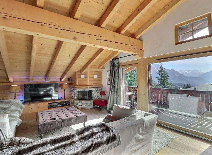 Experience luxury living in this stunning chalet, featuring a cozy fireplace and a spacious living area.