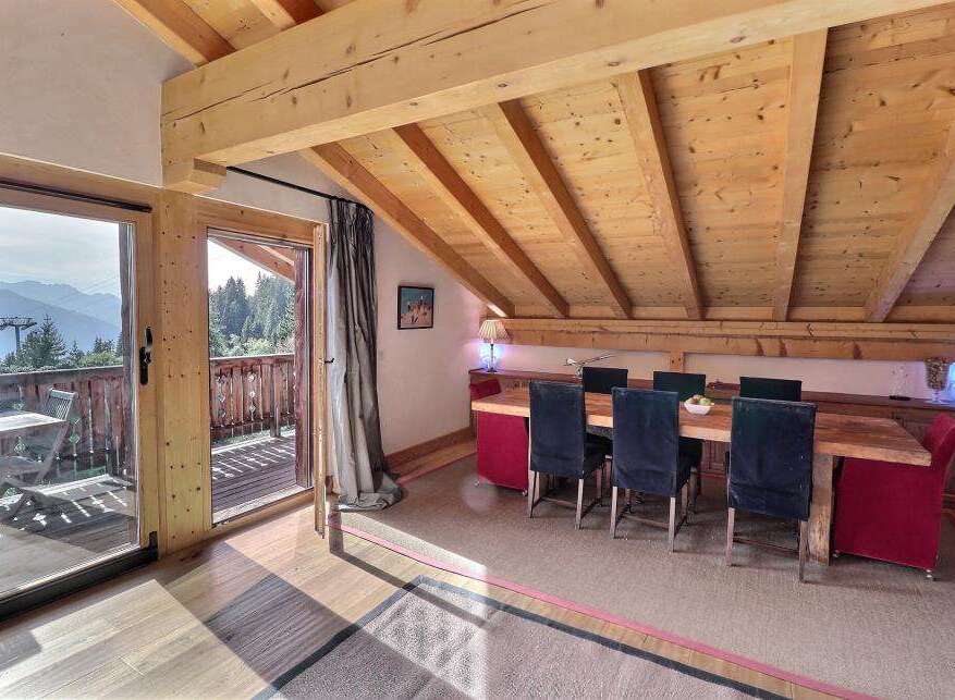 Experience the charm of this stunning property, featuring a spacious dining area with a rustic wooden table and chairs.