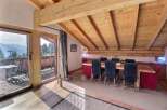 Experience the charm of this stunning property, featuring a spacious dining area with a rustic wooden table and chairs.