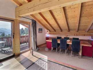Experience the charm of this stunning property, featuring a spacious dining area with a rustic wooden table and chairs.