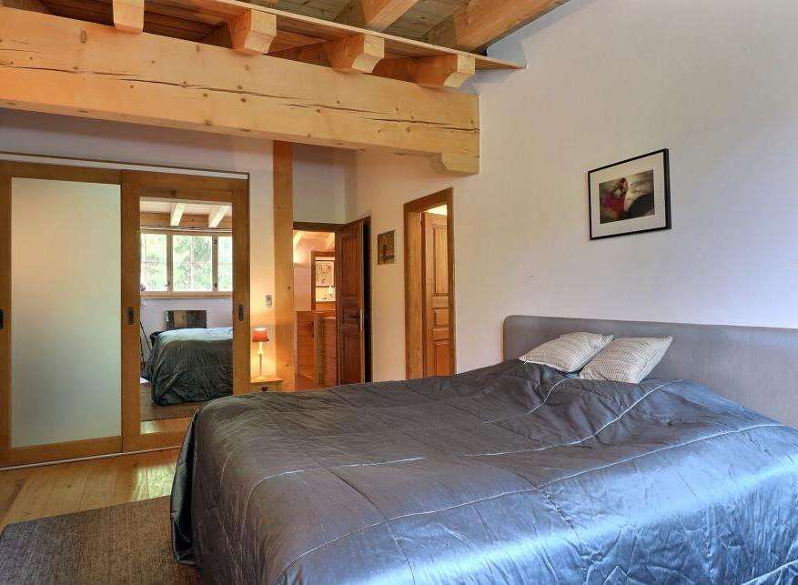 This cozy bedroom features a rustic design with wooden beams and a comfortable bed.