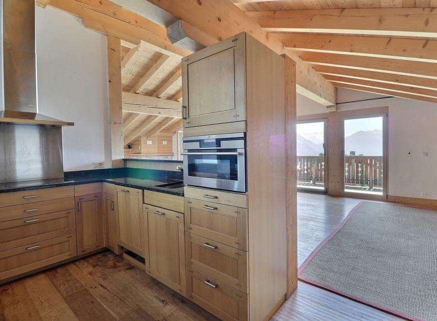 This stunning kitchen boasts a modern design with natural wood cabinetry and sleek stainless steel appliances.