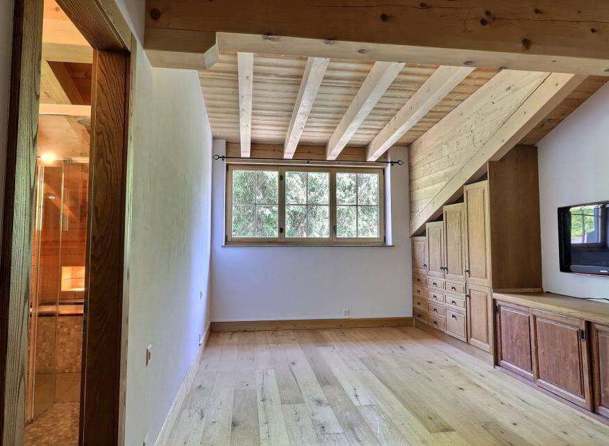 This stunning property boasts a unique architectural design with exposed wooden beams and a warm, inviting atmosphere.