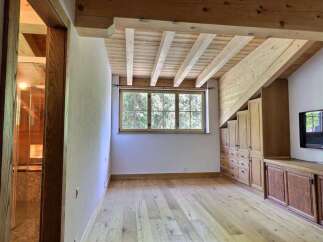 This stunning property boasts a unique architectural design with exposed wooden beams and a warm, inviting atmosphere.