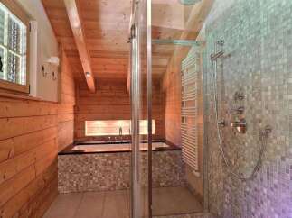This luxurious bathroom features a stunning combination of wood and mosaic tile, creating a warm and inviting atmosphere.