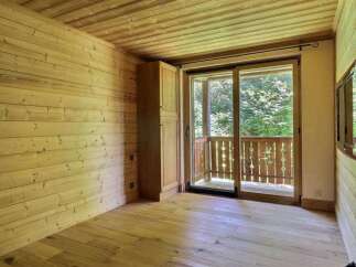 This cozy room features beautiful wooden walls and flooring, creating a warm and inviting atmosphere.
