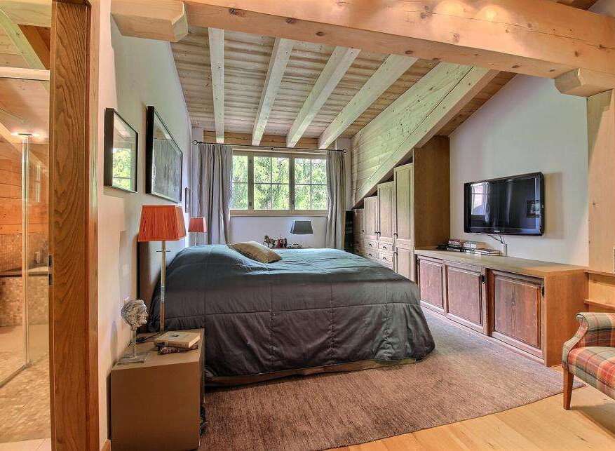 This stunning bedroom boasts a rustic charm with its exposed wooden beams and cozy ambiance.