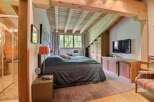 This stunning bedroom boasts a rustic charm with its exposed wooden beams and cozy ambiance.