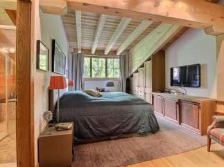 This stunning bedroom boasts a rustic charm with its exposed wooden beams and cozy ambiance.