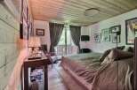This cozy bedroom features a rustic wooden ceiling and walls, creating a warm and inviting atmosphere.