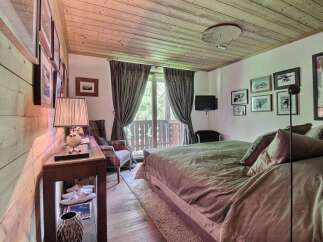 This cozy bedroom features a rustic wooden ceiling and walls, creating a warm and inviting atmosphere.