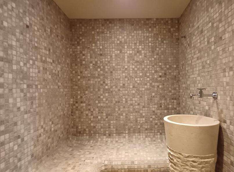 Step into luxury with this stunning bathroom featuring a unique mosaic tile design.
