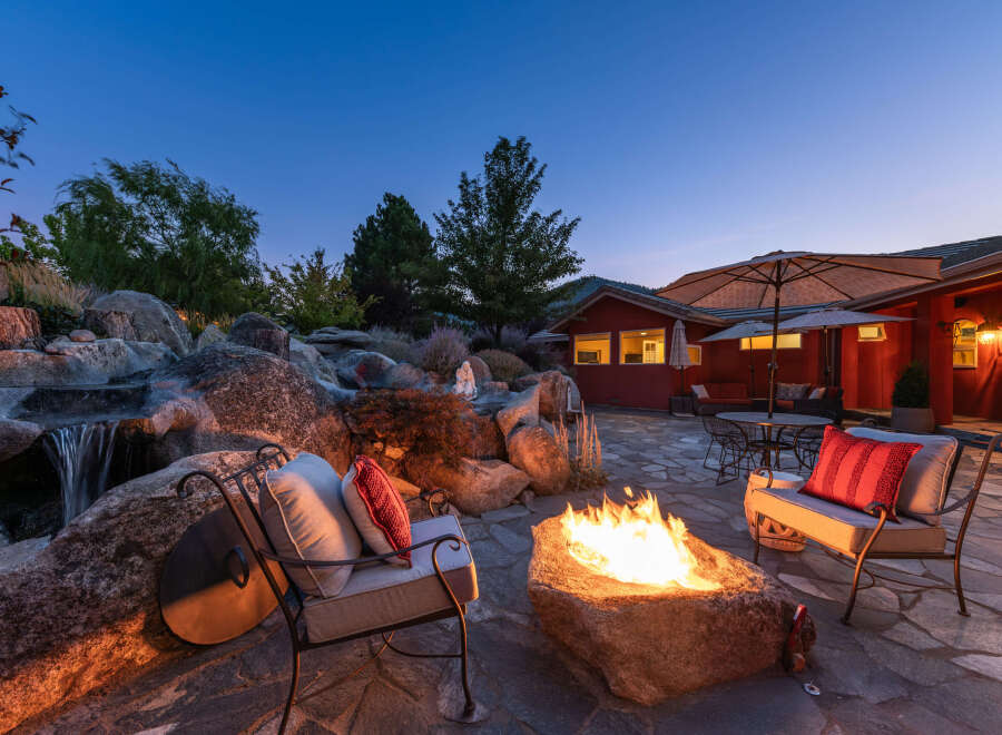 Experience the ultimate outdoor oasis with this stunning property! Featuring a cozy fire pit, perfect for evening gatherings, and a serene waterfall feature, this home offers a blend of relaxation and entertainment.