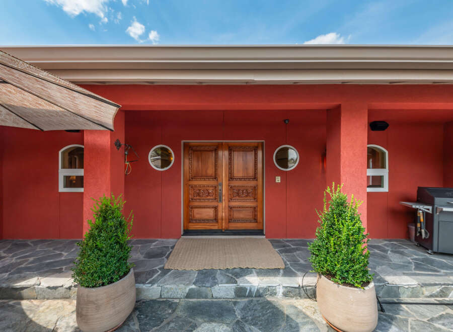 This stunning property boasts a striking red exterior, creating a bold and inviting first impression.