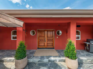 This stunning property boasts a striking red exterior, creating a bold and inviting first impression.