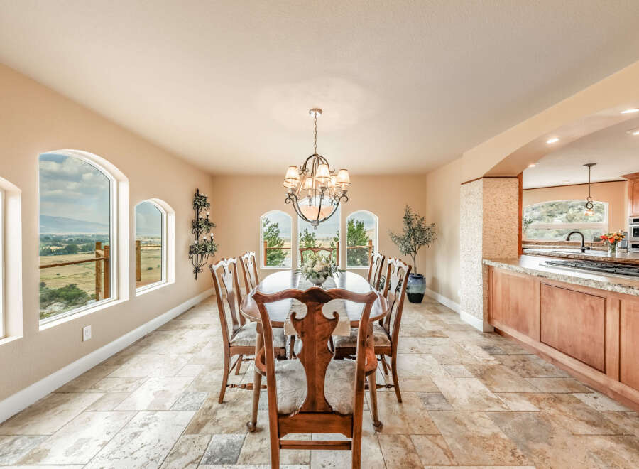 This elegant dining room features a stunning chandelier and a large oval dining table, perfect for hosting gatherings.
