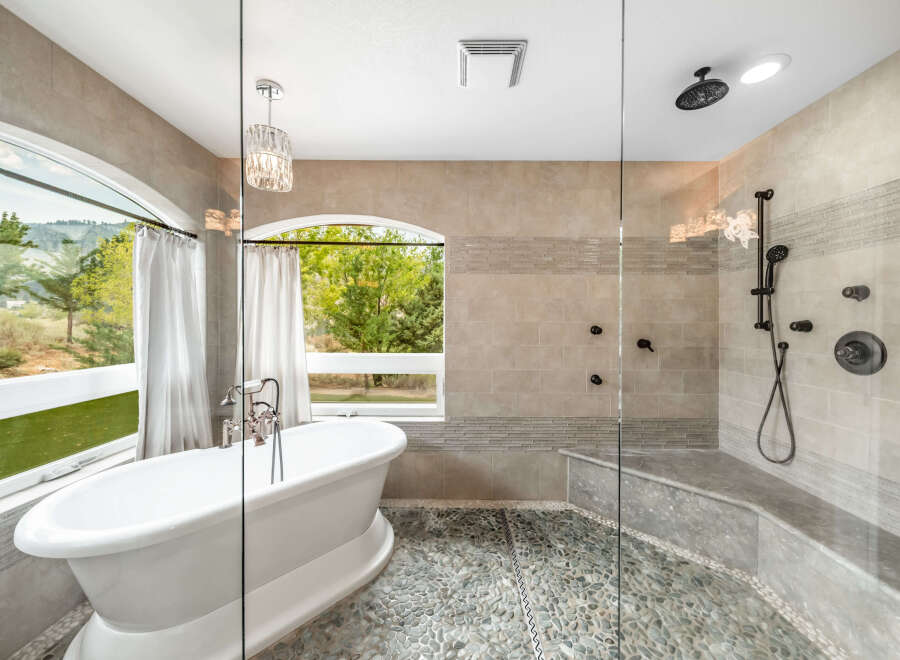 Step into luxury with this stunning bathroom featuring a freestanding tub and a separate glass-enclosed shower.