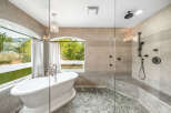 Step into luxury with this stunning bathroom featuring a freestanding tub and a separate glass-enclosed shower.