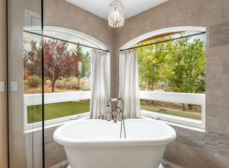 Indulge in the luxury of this stunning bathroom, featuring a beautiful freestanding tub and a breathtaking view.