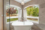 Indulge in the luxury of this stunning bathroom, featuring a beautiful freestanding tub and a breathtaking view.